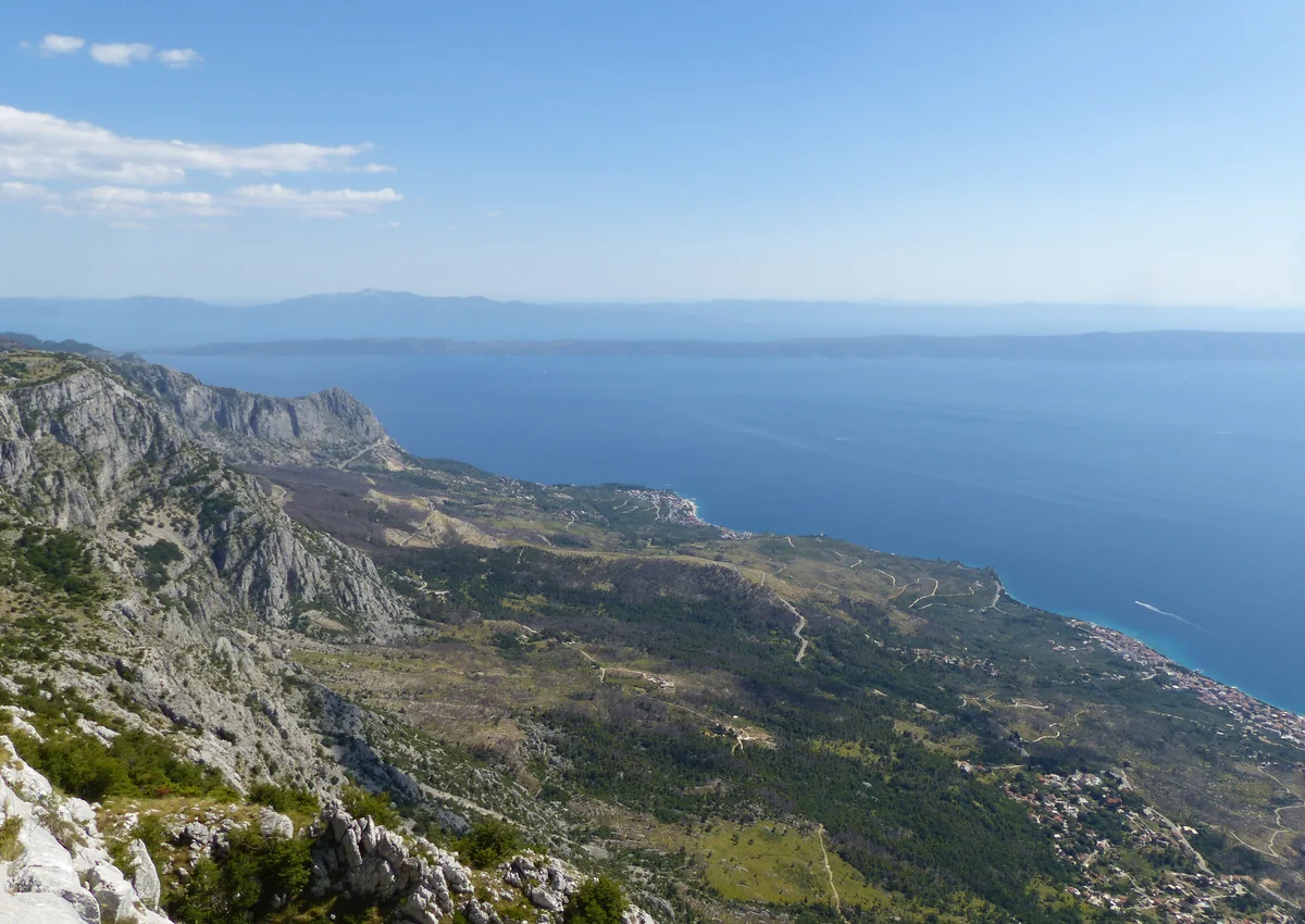 Otvorený horizont nad morom a horskou krajinou